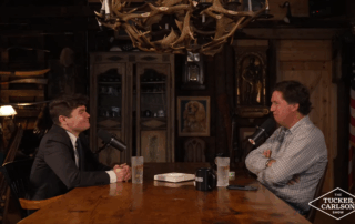 Tucker Carlson and Nick Fuentes sit across from each other during an interview on The Tucker Carlson Show, discussing politics, relationships, and modern culture.